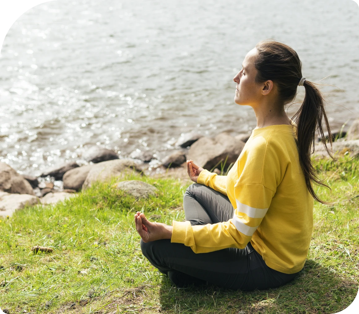 Woman meditating by a lakeside
