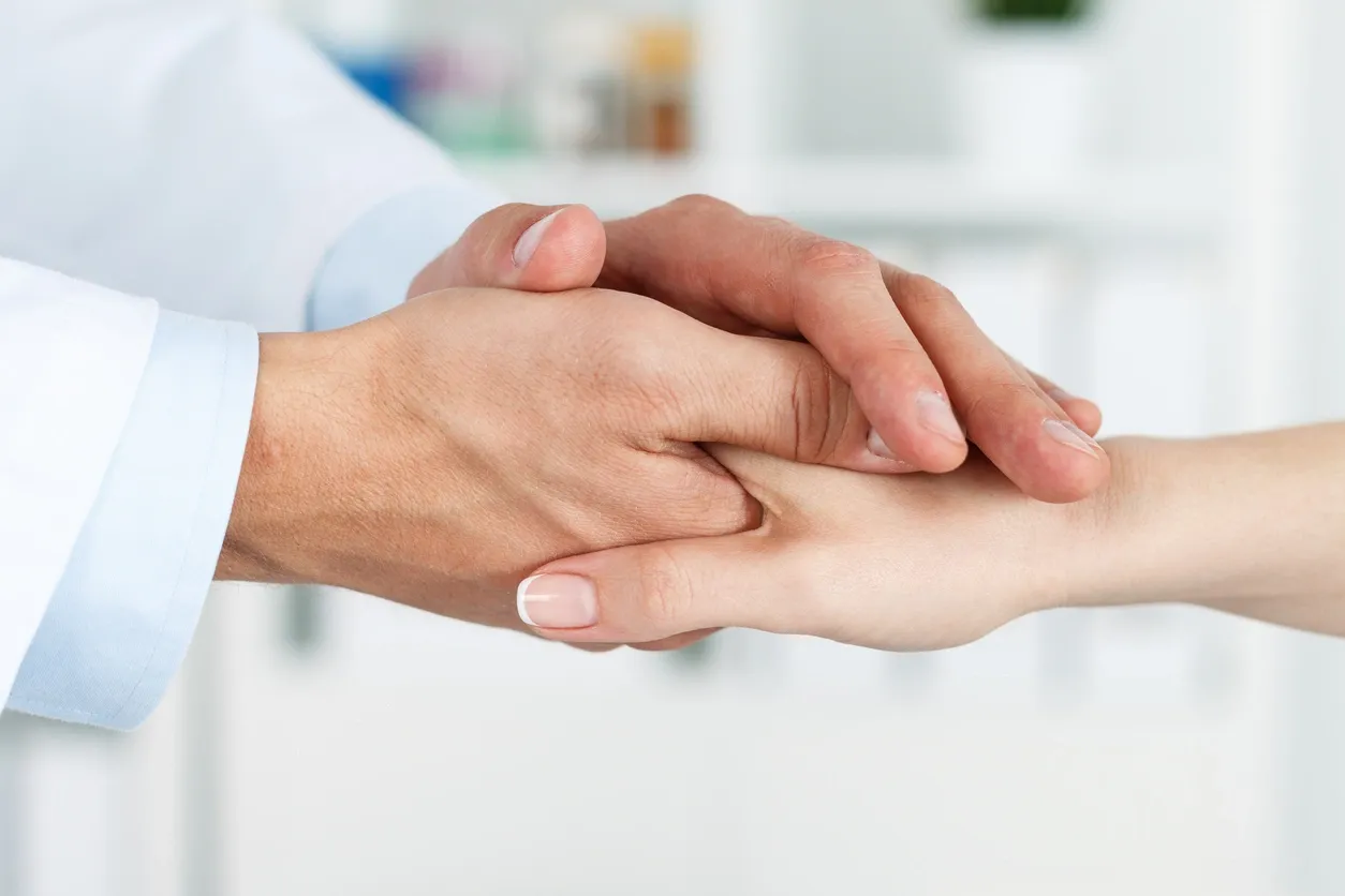 Compassionate healthcare professional holding hand