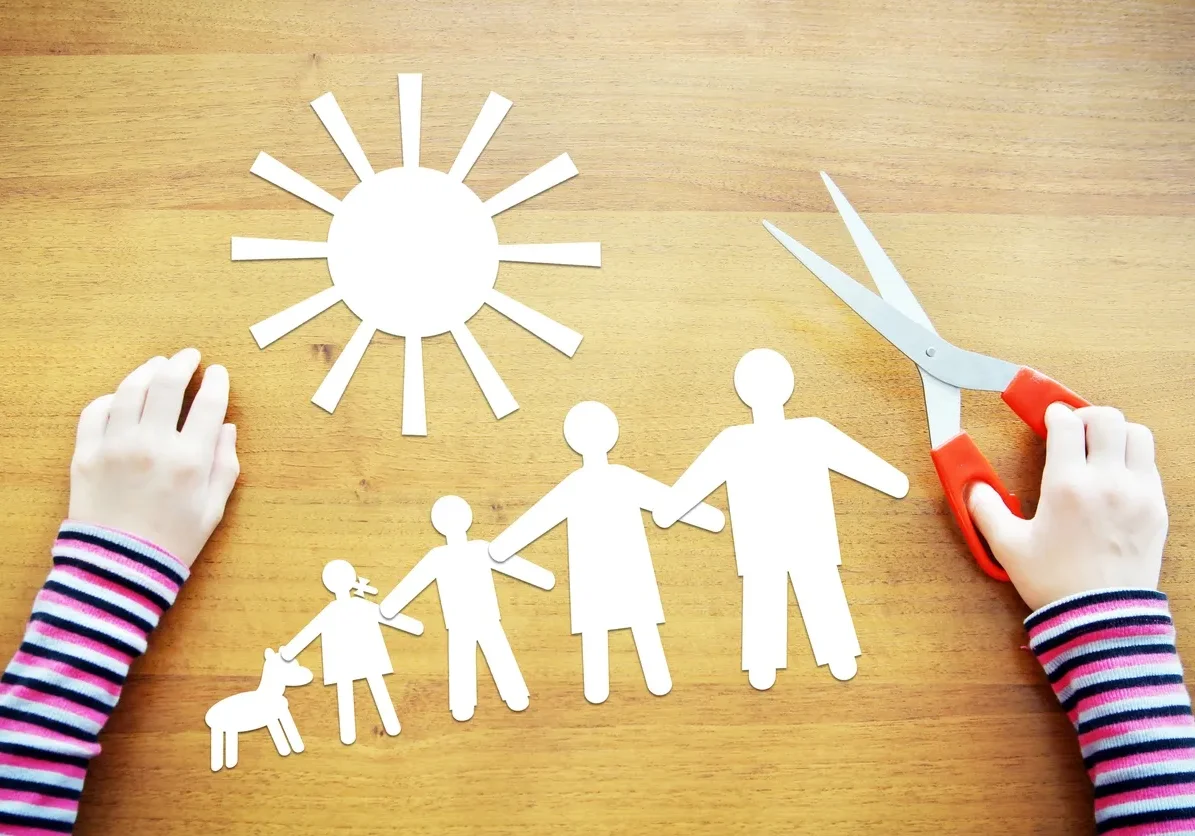 Hands crafting paper family and sun