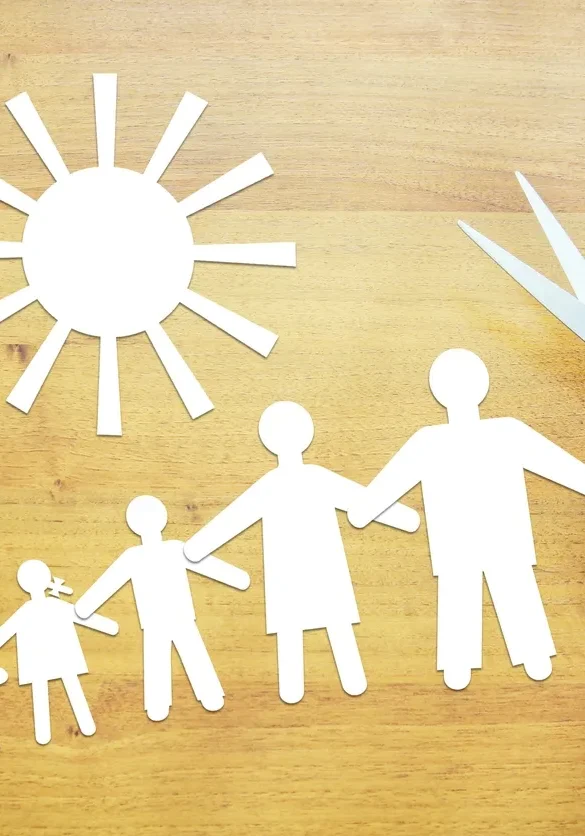 Hands crafting paper family and sun