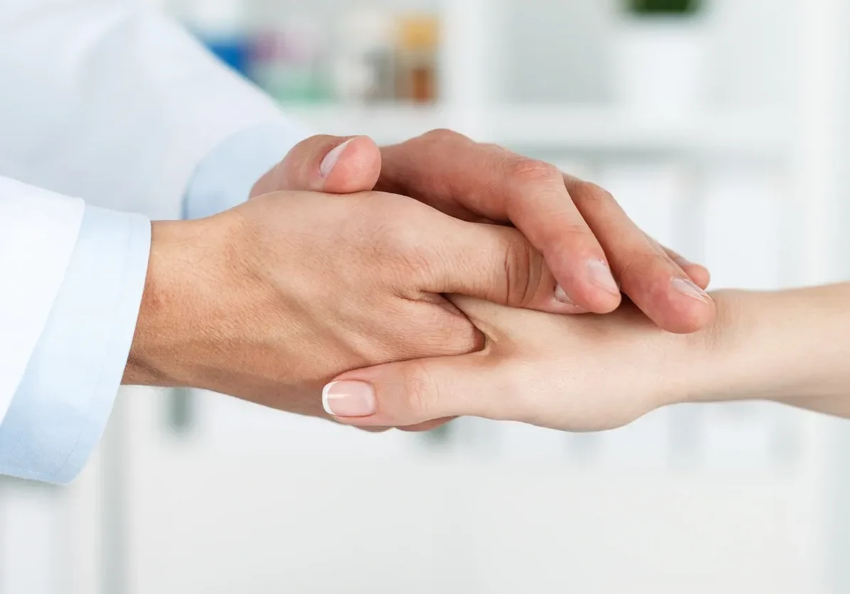 Compassionate healthcare professional holding hand